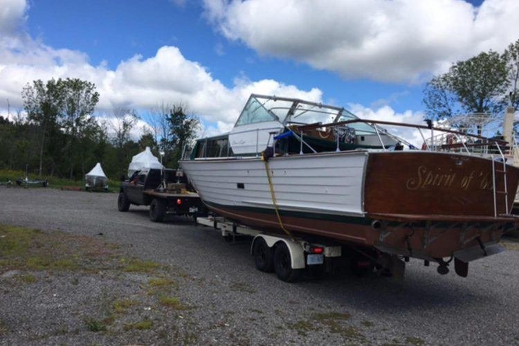 wooden boat being pulled on a trailer