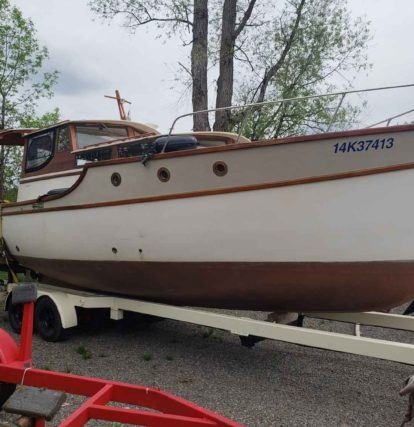 wooden boat on an trailer in a parking lot