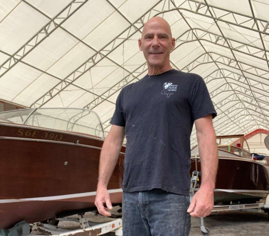 a man standing next to a boat in a building